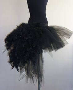 a mannequin wearing a black dress with feathers on it