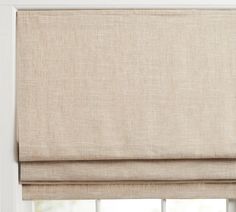 a beige roman blind in front of a window