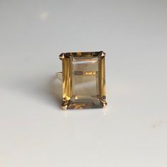 A vintage 9 carat gold ring, displaying a lovely sized Tourmaline. The stone is held by a simple style gold setting that frames the stone perfectly, holding it nice and snug. CONDITION: Wear consistent with age and use. Please see photos for more detail. BAND WIDTH: 1.5mm SETTING HEIGHT: 10mm STONE FACE: 20mm X 15mm RING SIZE: UK: M | US: 6 1/4 WEIGHT: 6.3 grams (UQZ) (696782) Classic Crystal Ring With Rectangular Gemstone, Timeless Citrine Rings For Formal Occasions, Formal Citrine Solitaire Birthstone Ring, Formal Solitaire Topaz Ring, Elegant Collectible Ring With Large Stone, Elegant Collectible Rings With Large Stone, Gold Emerald Ring With Rectangular Stone For Formal Occasions, Classic Open Crystal Ring For Formal Occasions, Timeless Open Crystal Formal Ring