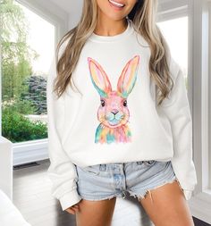 We absolutely love this beautiful and trendy watercolor bunny print for spring and Easter. It's the perfect whimsical and cozy sweatshirt for your wardrobe.  A sturdy and warm sweatshirt bound to keep you warm in the colder months. A pre-shrunk, classic fit sweater that's made with air-jet spun yarn for a soft feel and reduced pilling. * 50% cotton, 50% polyester * Pre-shrunk * Classic fit * 1x1 athletic rib knit collar with spandex * Air-jet spun yarn with a soft feel and reduced pilling * Doub Spring Crew Neck Tops With Bunny Design, White Bunny Print Crew Neck Top, White Crew Neck Tops With Bunny Print, White Crew Neck Top With Bunny Print, White Bunny Print Top For Spring, Casual White Tops With Watercolor Print, Casual White Top With Watercolor Print, Casual White Easter Tops, Casual White Tops For Easter