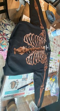 there is a skeleton on the table next to newspapers and other items that have been placed around it