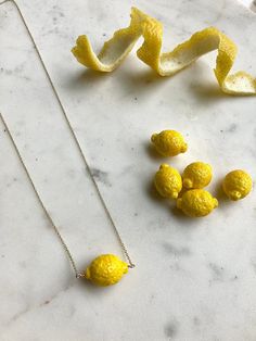 I love lemons! I go through at least two of them per day and honestly can't live without them. They're a humble fruit with major health benefits. Their versatility makes them a staple since you can eat them, clean with them, and use them as an exfoliating face mask 🥰 🍋 This is a detailed miniature lemon necklace. The little fruit is made of durable handblown glass. It has a bright sunny yellow hue and is just the right size✨ Each lemon measures between 15-20 mm in width 🍋The chain is availabl Lemon Jewelry Dish, Polymer Clay Lemon, Lemon Jewelry, Fruits Necklace, Fruit Charm Necklace, Lemon Necklace, Exfoliating Face Mask, Exfoliating Face, Lemon Fruit