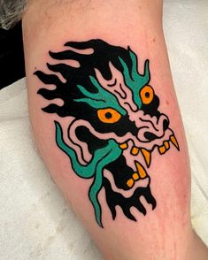 a close up of a person with a tattoo on their leg and the head of a dragon