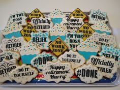 there are many decorated cookies in the tray on the table with congratulations written on them