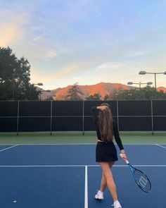 a woman standing on top of a tennis court holding a racquet in her hand