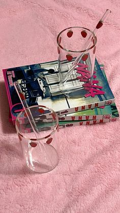 a book and glass on a pink blanket with a straw sticking out of the top