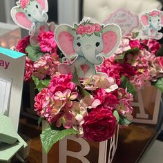 there are flowers in the vases with an elephant on them and cards attached to it