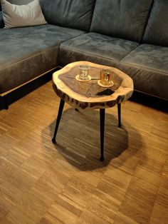 a couch and table in a room with wood flooring next to a gray couch