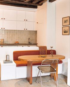 a small kitchen with a table and chairs in the corner, next to a couch