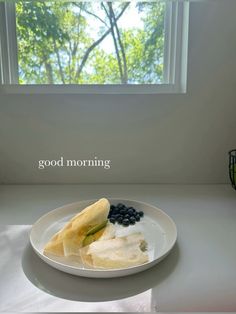 a white plate topped with fruit and vegetables next to a window that reads good morning