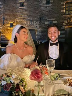 a bride and groom sitting at a table