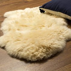 a sheepskin rug on the floor next to a pillow