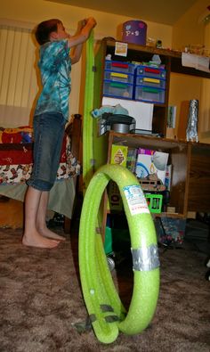 a young boy is playing with an inflatable tube on the floor while another child watches