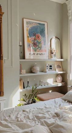 a bedroom with a bed, shelves and pictures on the wall