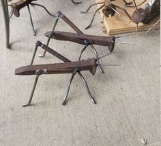 several metal sculptures sitting on top of a floor next to books and other items that are laying on the ground