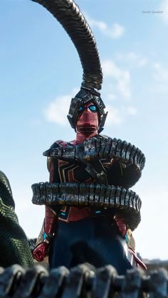 a man dressed in armor with large horns and huge tires on his head is standing next to another person