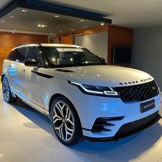 a white range rover parked in a showroom