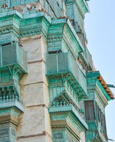 an old building with many balconies on the top and bottom windows, painted green