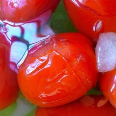 some red and green vegetables are on a plate with water droplets all over the surface