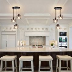 a kitchen with three stools and an island