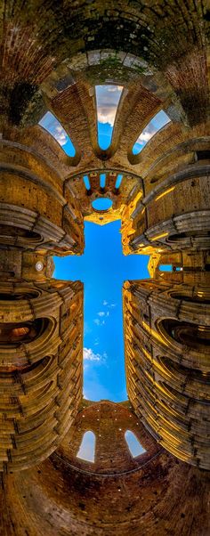 the view from inside an old building looking up at the sky and clouds in the distance