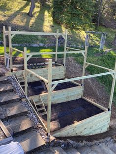 an elevated garden bed with steps leading up to it and plants growing in the soil