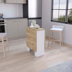 an empty kitchen with two stools next to the counter