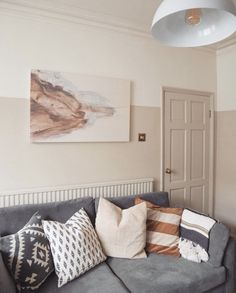 a living room with a gray couch and several pillows on the back of it's sofa