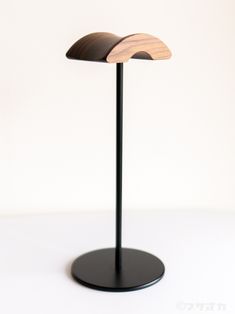 a wooden table lamp sitting on top of a black stand