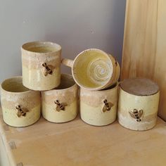 a group of ceramic jars sitting on top of a wooden table