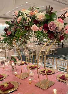 the centerpieces are adorned with pink flowers and greenery, along with gold chargers