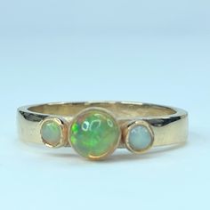 an opal and gold ring with three stones