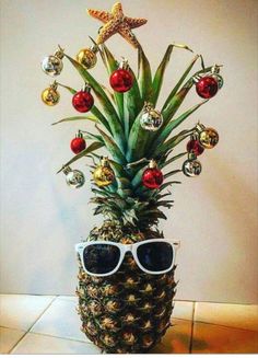 a pineapple decorated with christmas ornaments and sunglasses