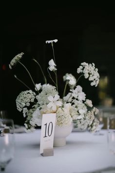 the table is set with white flowers and place cards