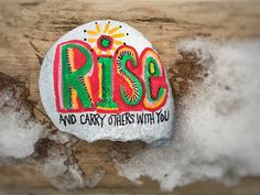 a painted rock that says rise and carry others with you