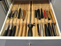 the drawer is full of different types of kitchen utensils and knives in it