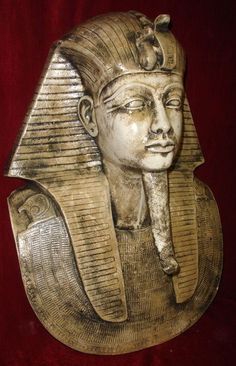 an egyptian statue is shown against a red background