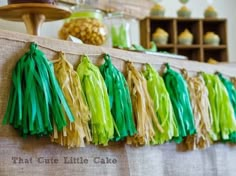 some tassels are hanging on the wall next to cupcakes and cakes