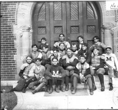 an old black and white photo of baseball players in front of a door with the number n on it