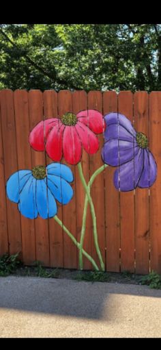 a wooden fence with painted flowers on it