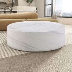 a large white marble coffee table sitting on top of a carpeted living room floor