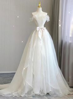 a white wedding dress on display in front of a window