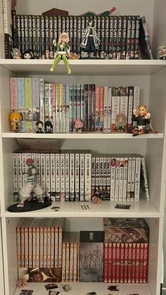 a book shelf filled with lots of books and anime figurines on top of it