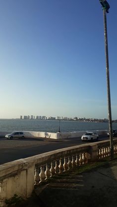 cars are parked on the road by the water