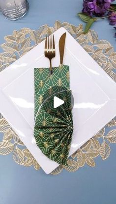 a green napkin with a fork and knife on top of it next to a white plate