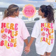 two girls in matching shirts holding hands