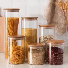 the jars are filled with different types of pasta and other foods in them, along with breadcrumbs