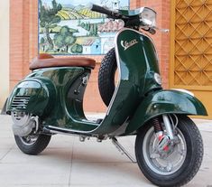 a green scooter parked in front of a building