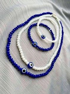 three blue and white beads with evil eyes on them