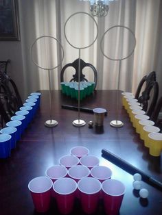 a table with plastic cups on it in front of a chandelier